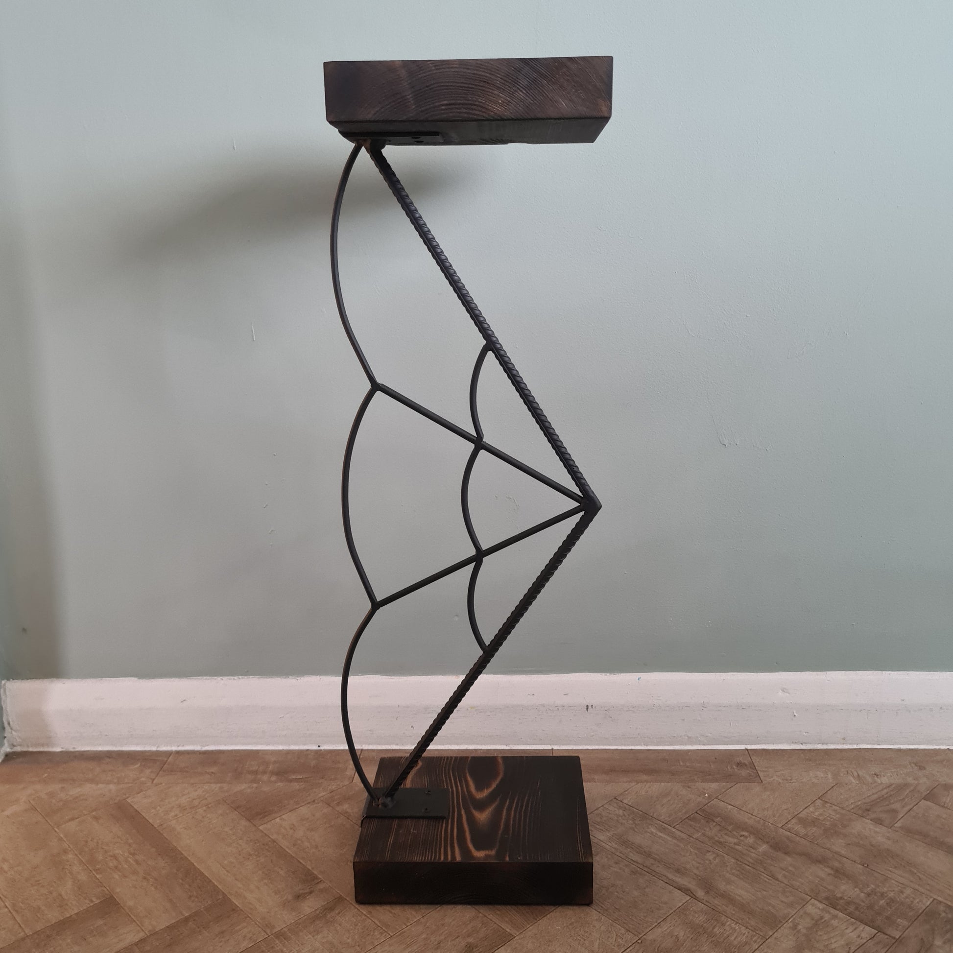 Decorative wall light fixture with wooden brackets on a neutral wall.