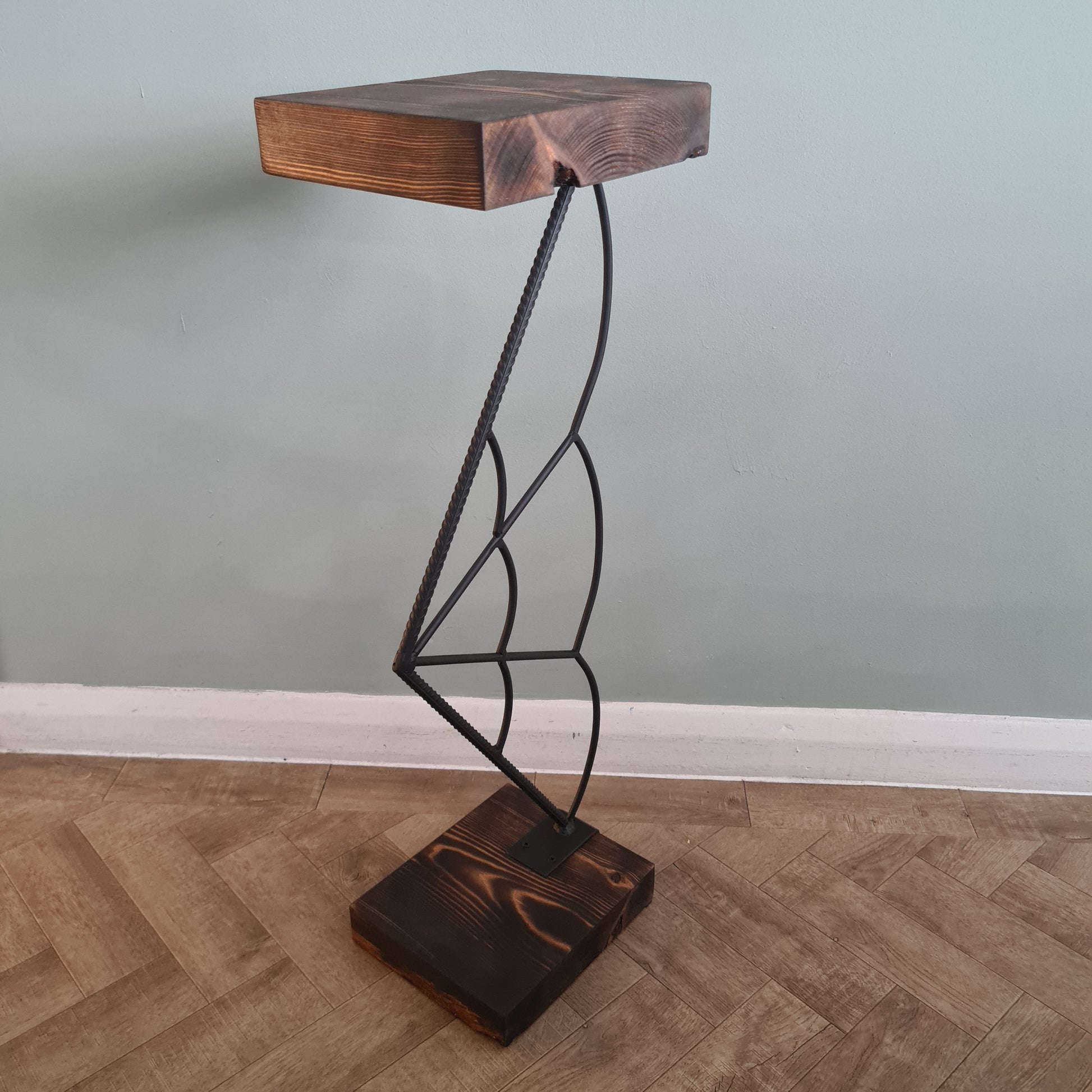Wooden bracket with metal wire shelf attached to a wall.
