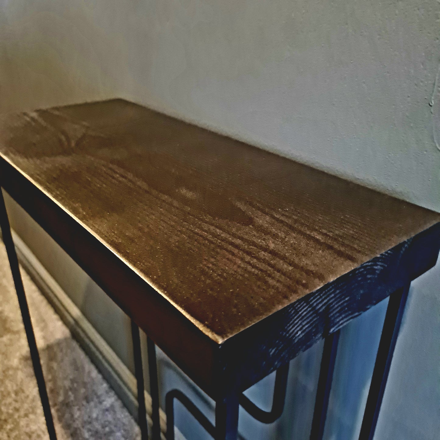 Wooden table with metal legs against a plain wall