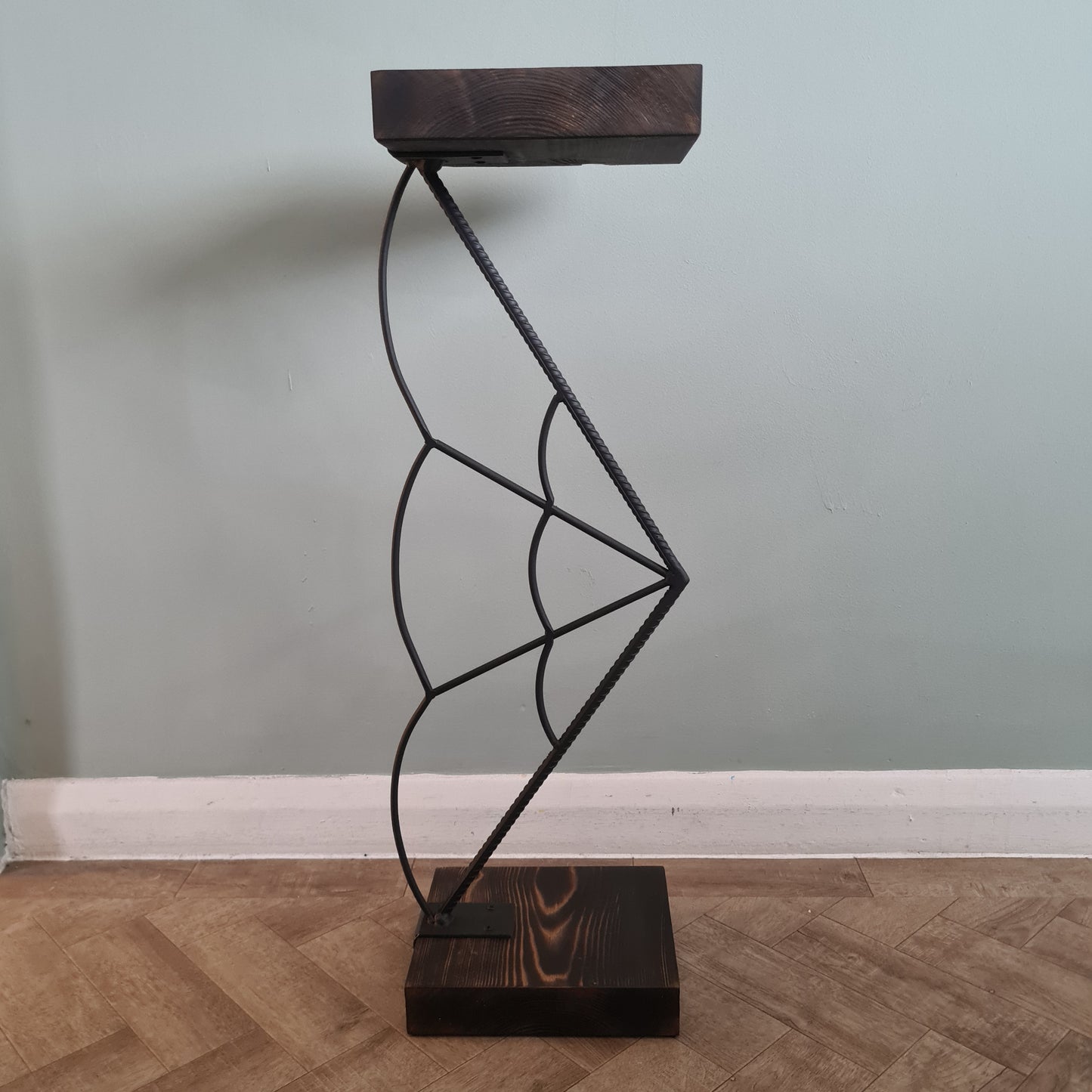 Decorative wall light fixture with wooden brackets on a neutral wall.